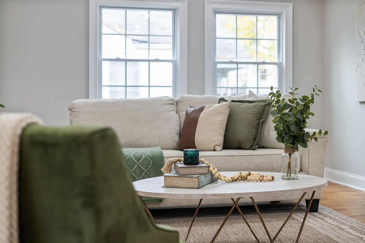 Bright living room with a cream sofa and green accents