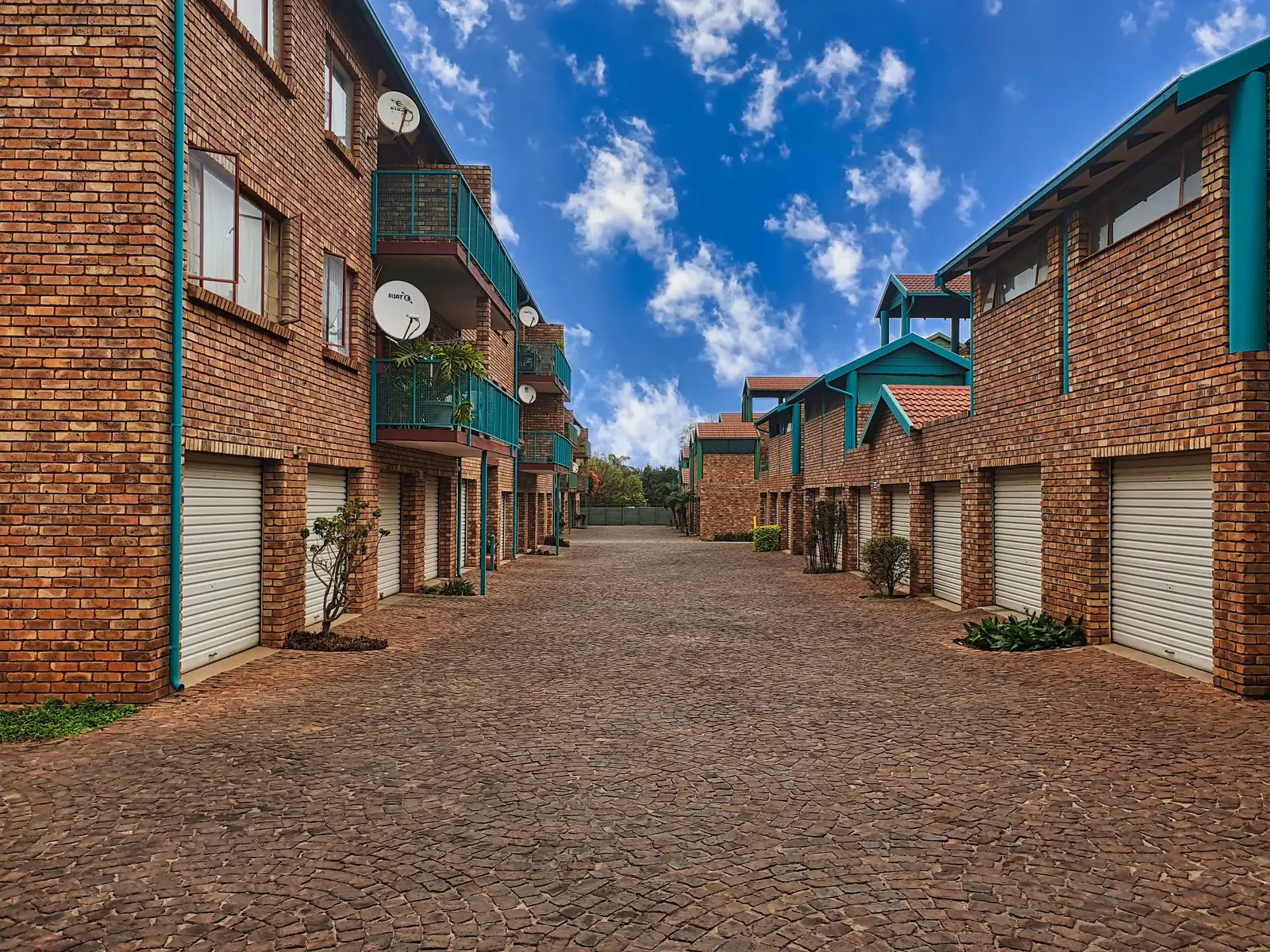 Brick townhouse complex with a paved lane